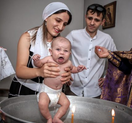 A touching baptism ceremony with a family and priest, capturing joyful expressions.